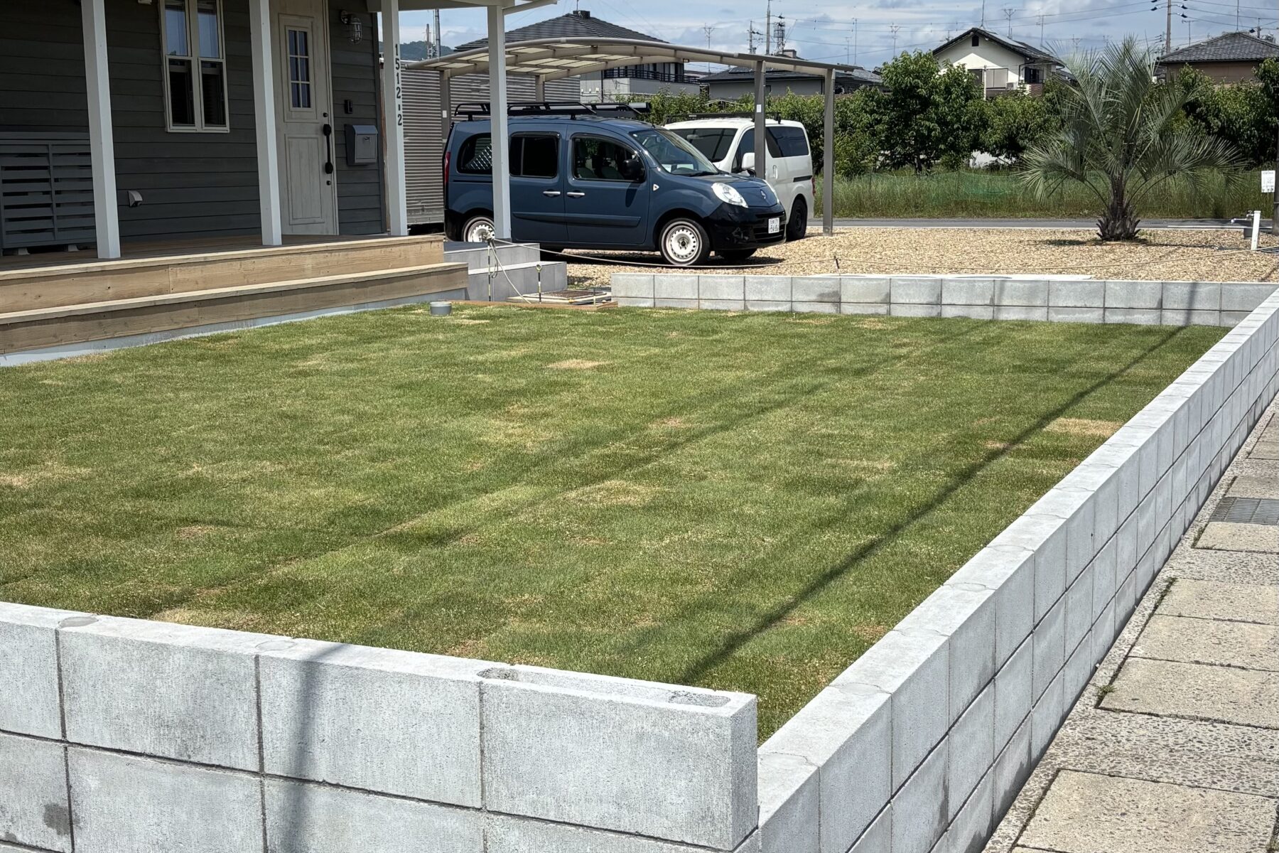 芝生の庭とウッドデッキのある平屋